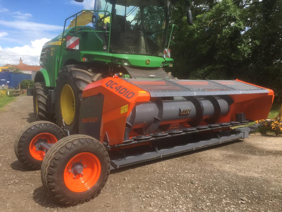 Whole crop header and trailer on John Deere